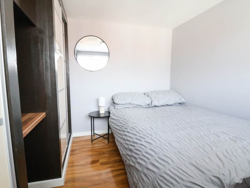 A bedroom with a bed and a nightstand at Seaside Home in New Brighton