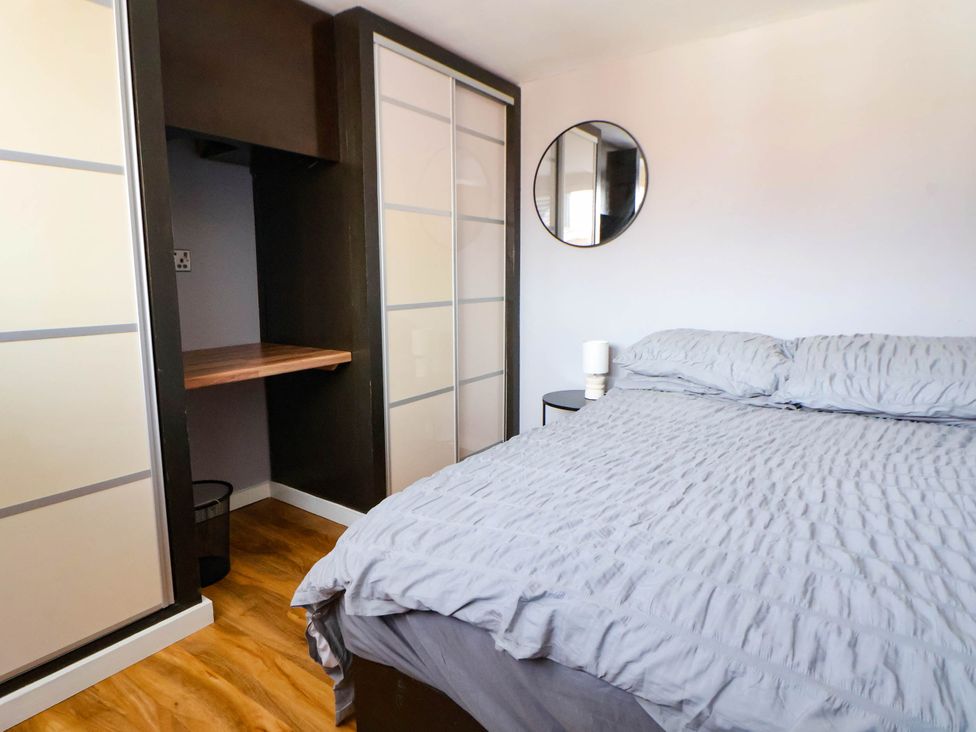 A bedroom with a bed and wardrobe at Seaside Home in New Brighton