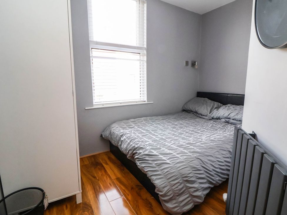 A bedroom with a bed and wardrobe at Seaside Home in New Brighton