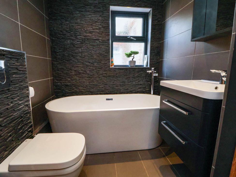 A bathroom with a bathtub, toilet, and sink at Seaside Home in New Brighton