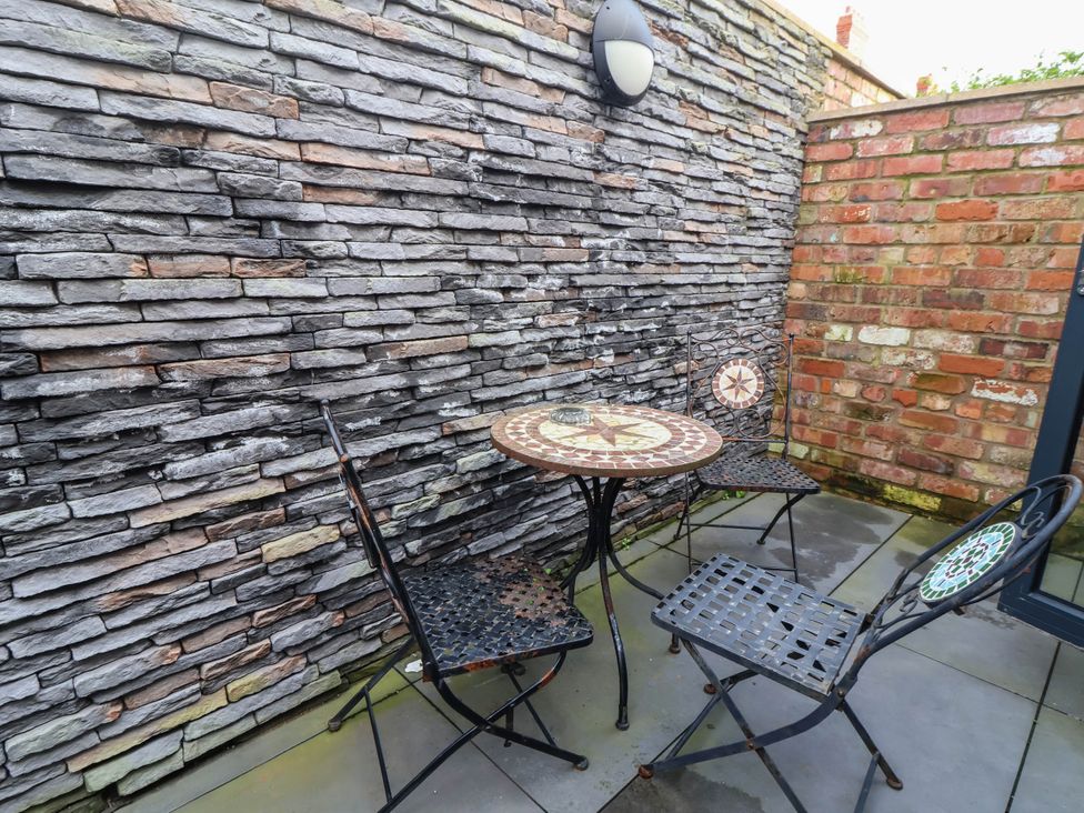 An outdoor patio with a table and chairs at Seaside Home in New Brighton