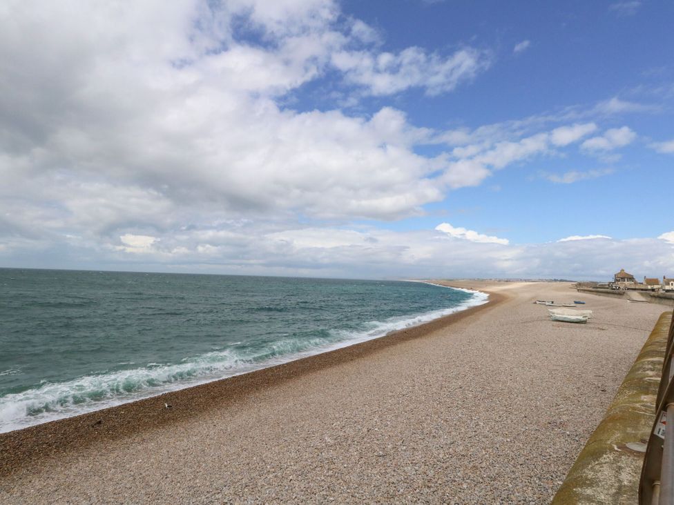 A beach with a sea and pebbles at Home from Home near the Sea in Weymouth