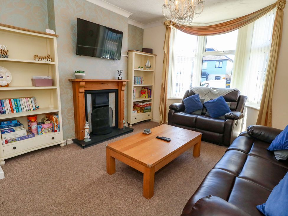 A living room with a fireplace and bookshelves at Home from Home near the Sea Weymouth