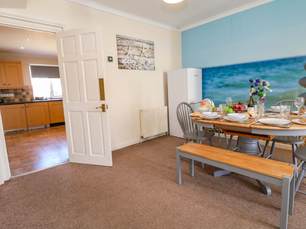 A dining area with a table and chairs at Home from Home near the Sea Weymouth