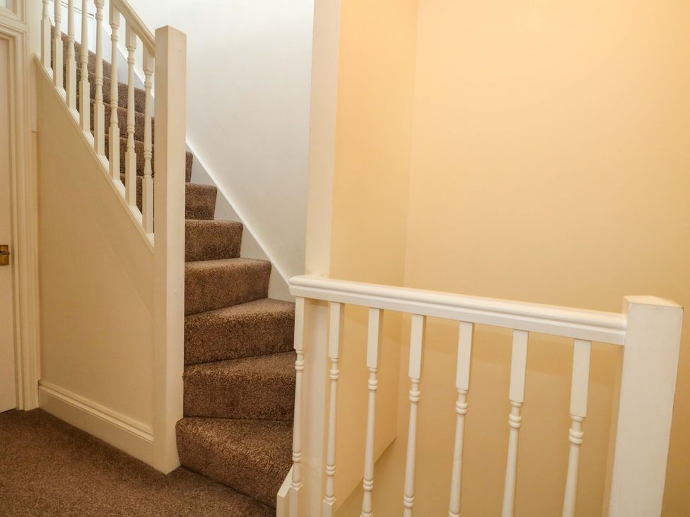 A staircase with a handrail and a door at Home from Home near the Sea Weymouth