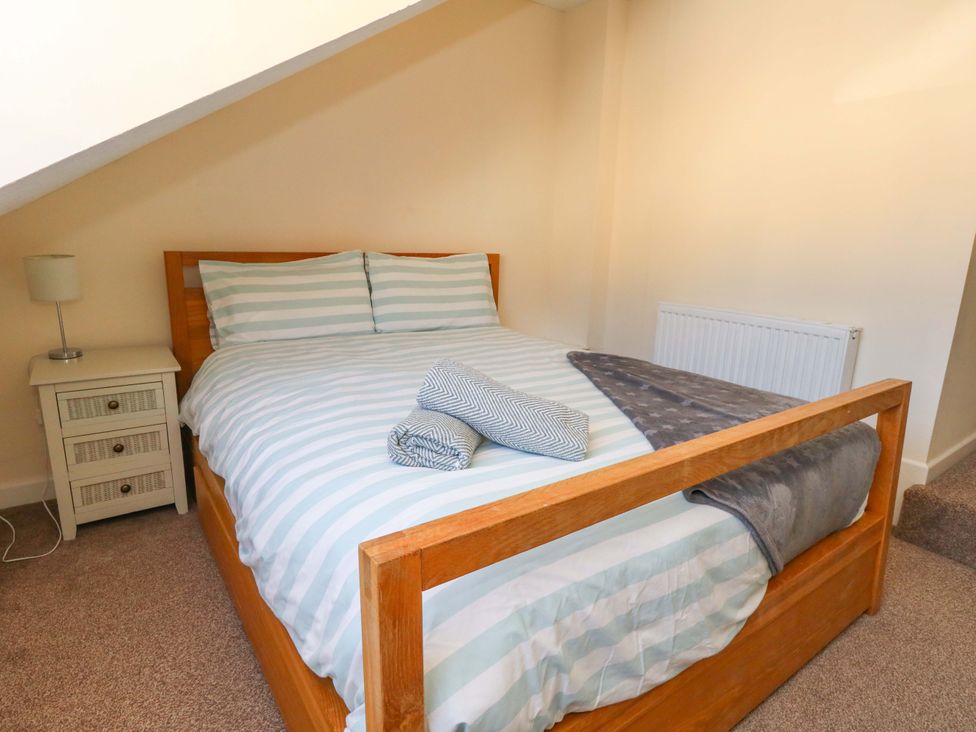 A bedroom with a bed and side table at Home from Home near the Sea in Weymouth