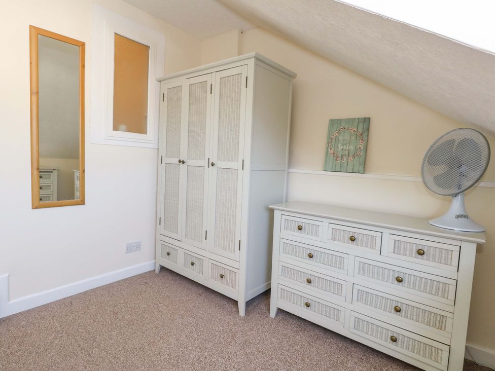 A bedroom with a wardrobe and chest of drawers at Home from Home near the Sea Weymouth