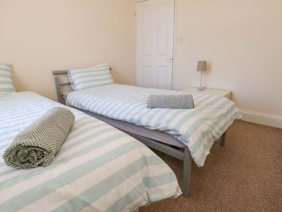 A bedroom with two single beds and a lamp at Home from Home near the Sea Weymouth