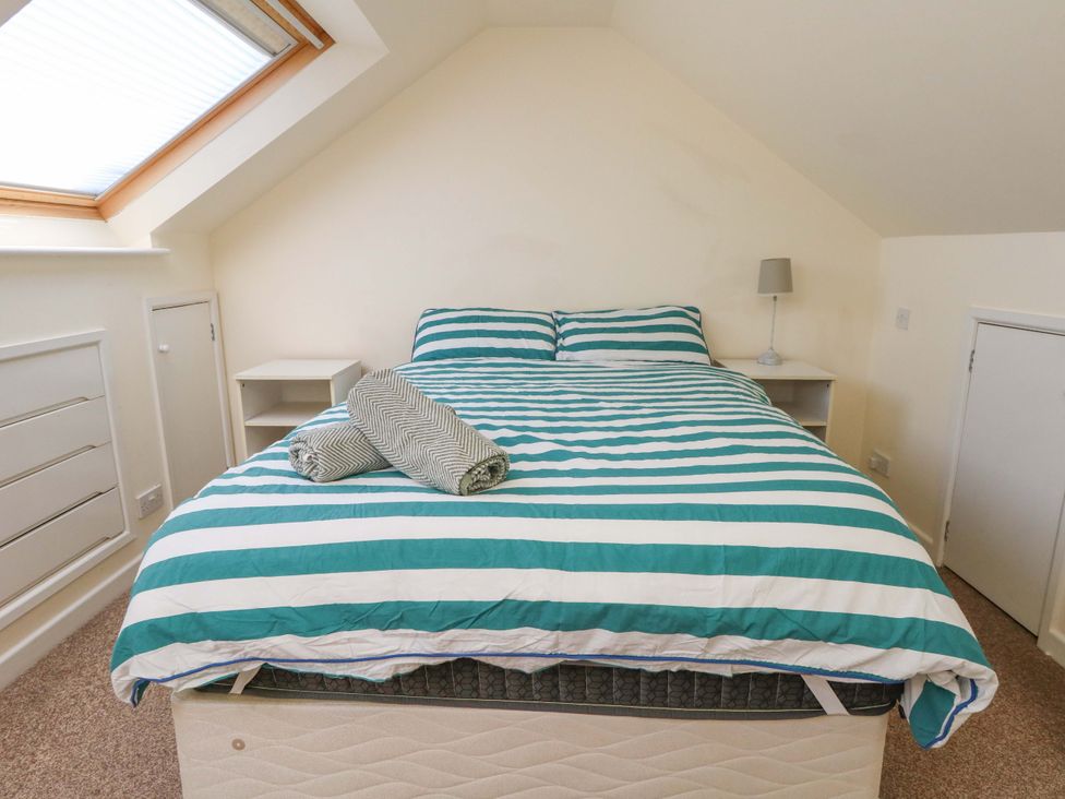 A bedroom with a bed and nightstand at Home from Home near the Sea Weymouth