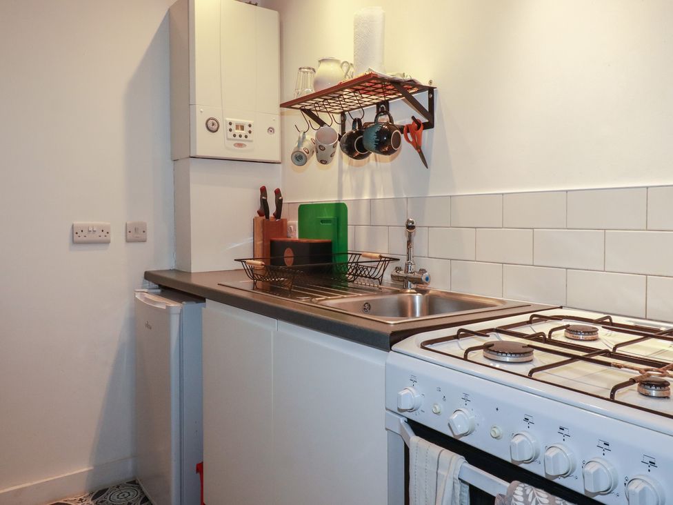 A kitchen with a sink and gas stove at Little Hallegan in Camborne