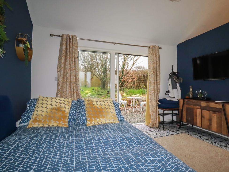 A bedroom with a bed and furniture at Little Hallegan, Camborne
