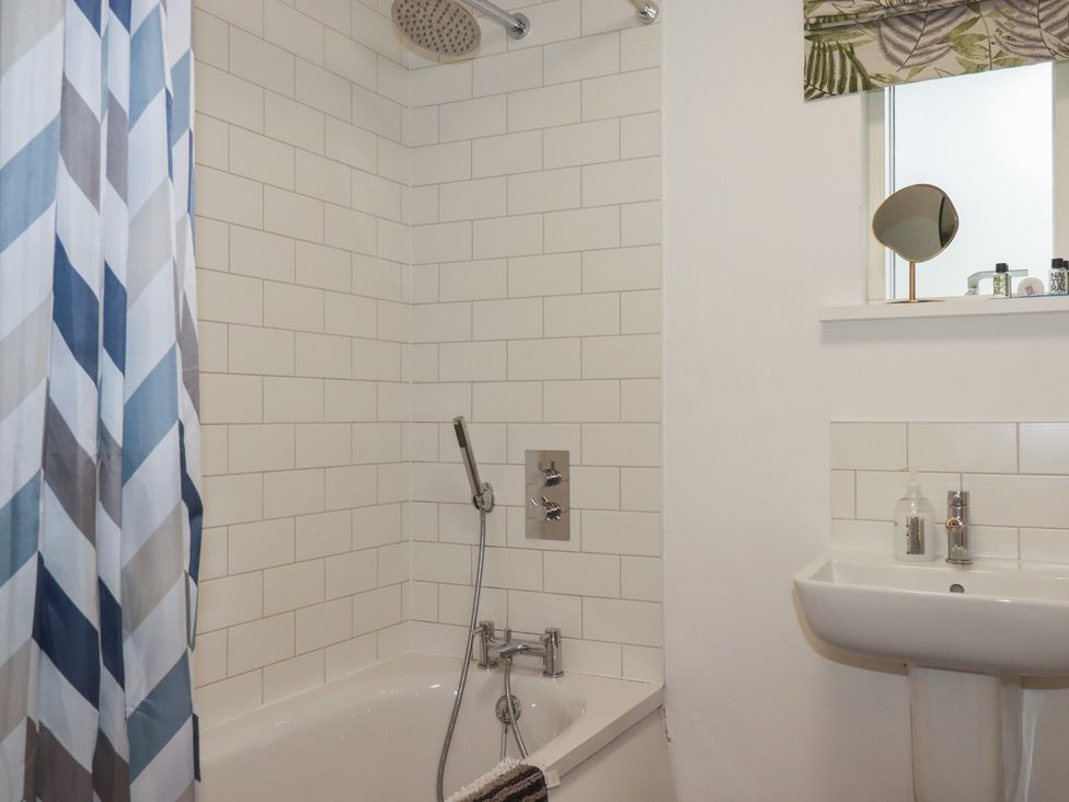 A bathroom with a bathtub and sink at Little Hallegan in Camborne