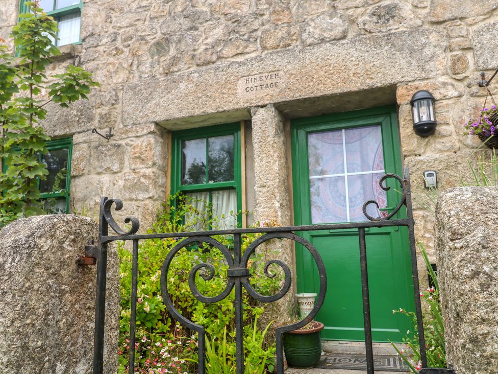 An entrance with a green door and stone wall at Ninevah in St. Ives