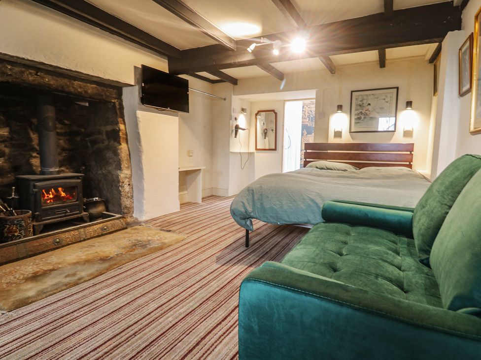 A bedroom with a bed and fireplace at Ninevah in St. Ives