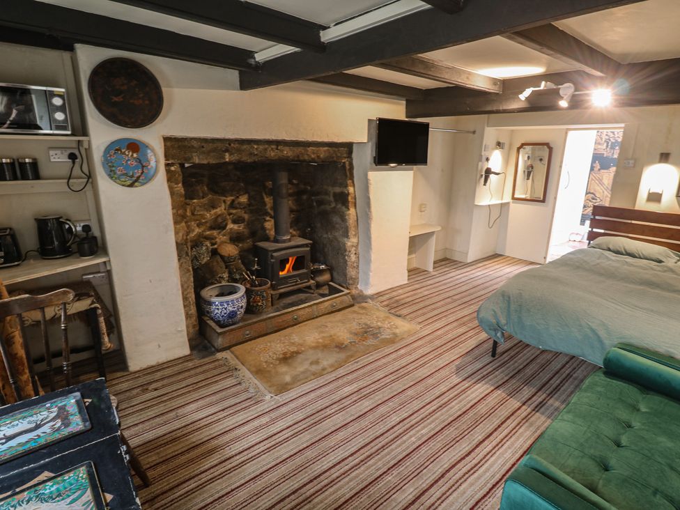 A living room with a fireplace and stove at Ninevah in St. Ives