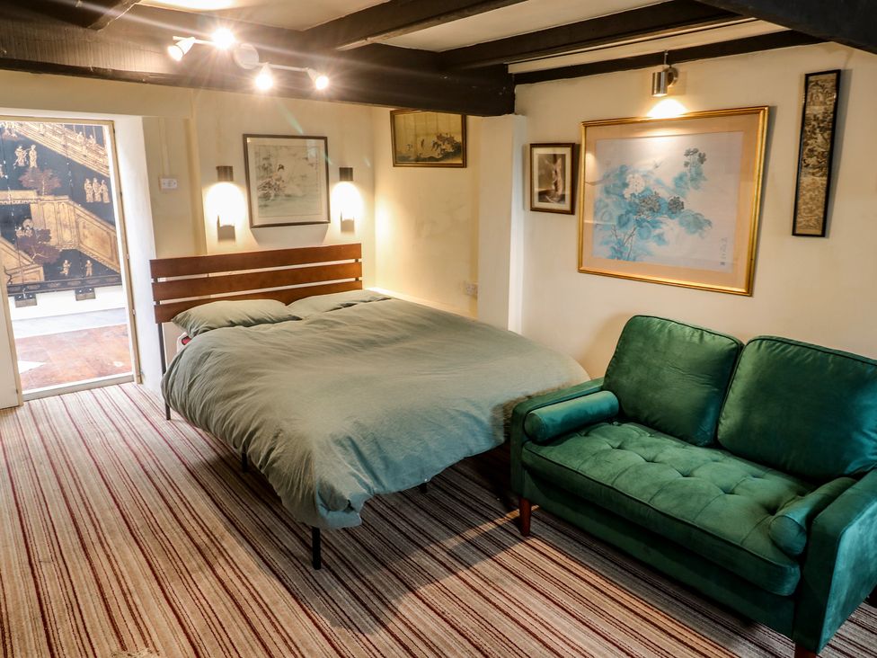 A bedroom with a bed and a sofa at Ninevah in St. Ives