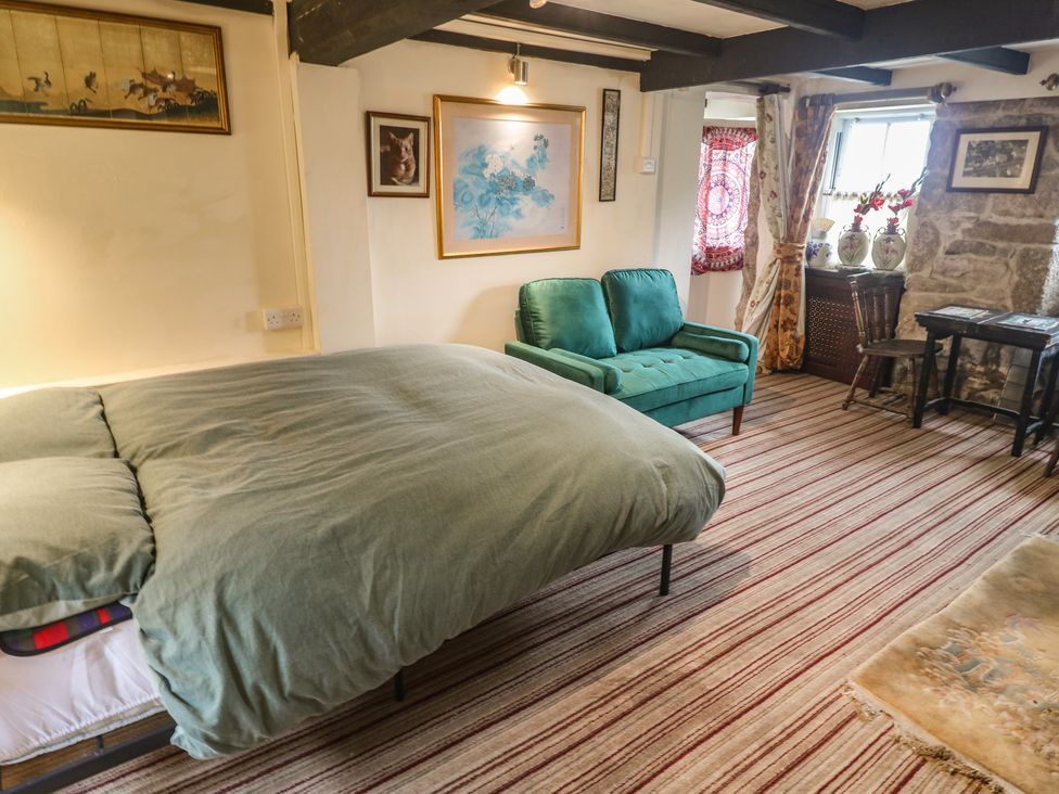 A bedroom with a bed and sofa at Ninevah in St. Ives