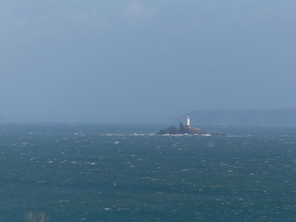 A lighthouse on a rock surrounded by ocean at Ninevah St. Ives