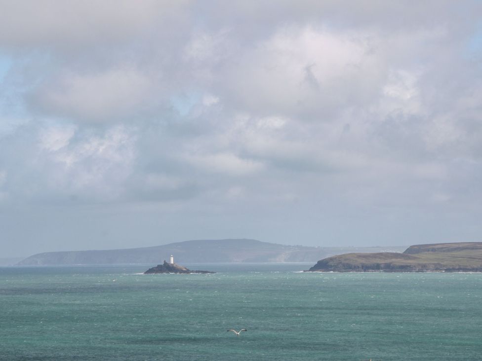A view of ocean with an island and lighthouse at Ninevah in St. Ives