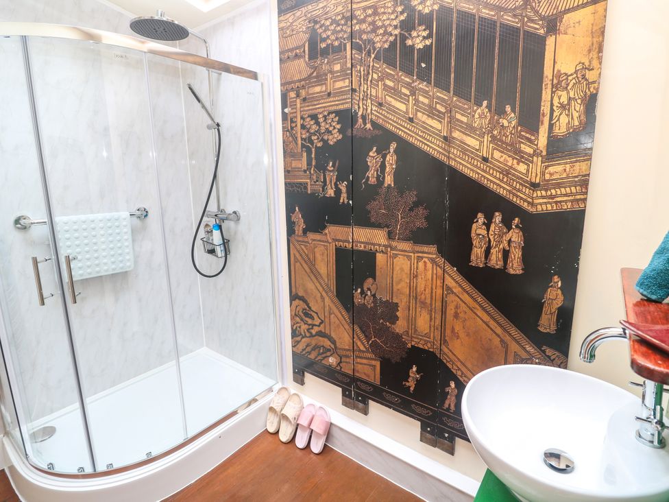 A bathroom with a shower and decorative wall art at Ninevah Lelant