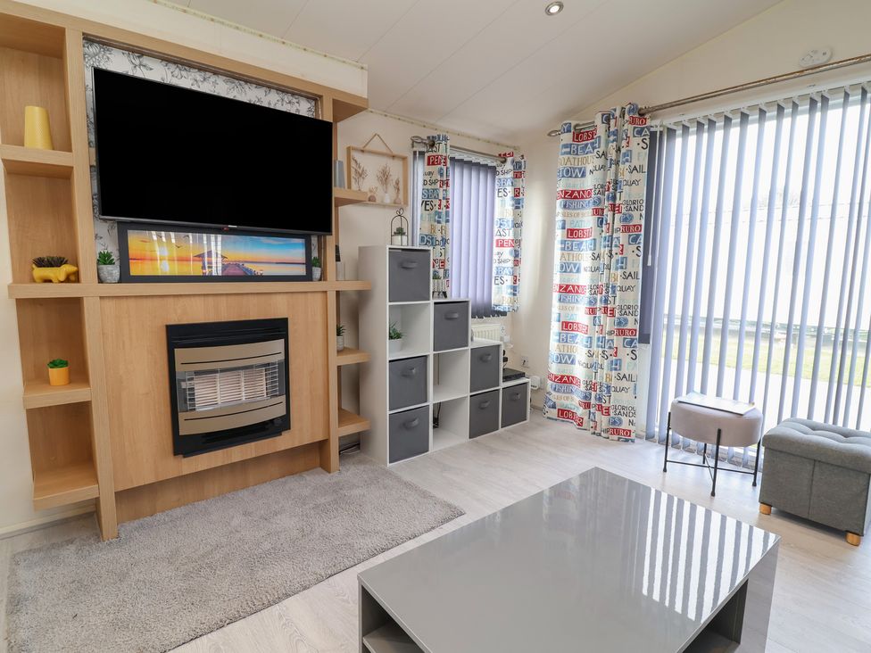 A living room with a television and fireplace at Carvan CP10 in Prestatyn