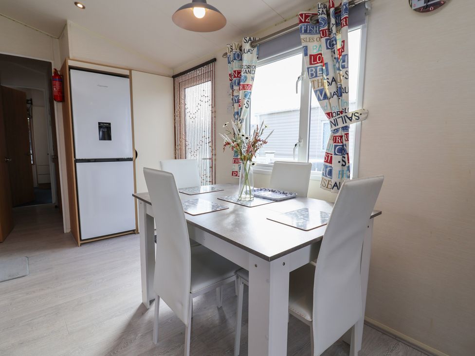 A dining room with a table and chairs at Carvan CP10 Prestatyn