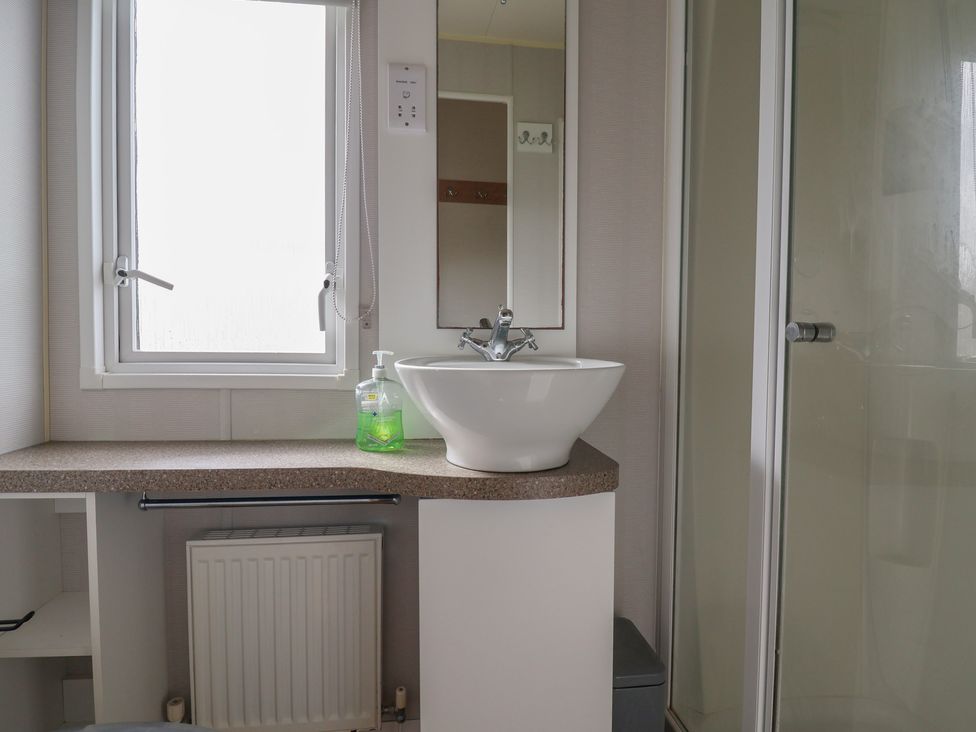 A bathroom with a sink and a shower at Carvan CP10, Prestatyn