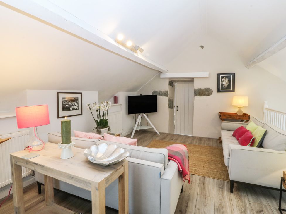 A living room with a sofa and coffee table at The Byre in Conwy