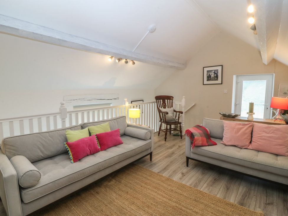 A living room with sofas and a lamp at The Byre in Conwy