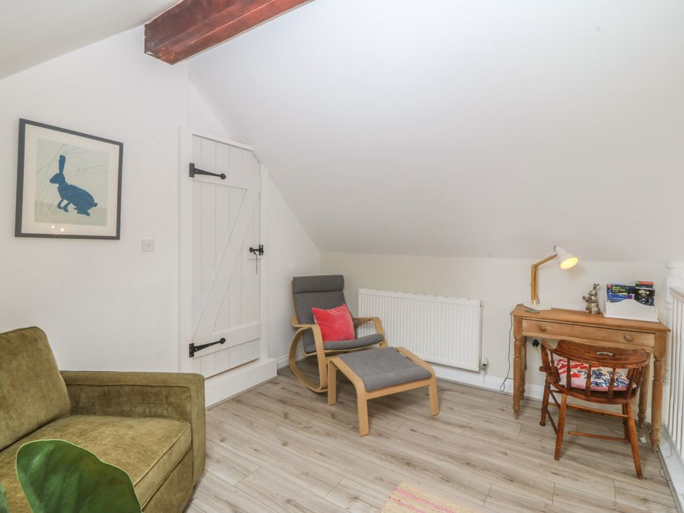 A snug with a chair, desk, and radiator at The Byre in Conwy