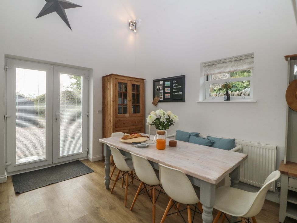 A dining room with a table and chairs at The Byre in Conwy