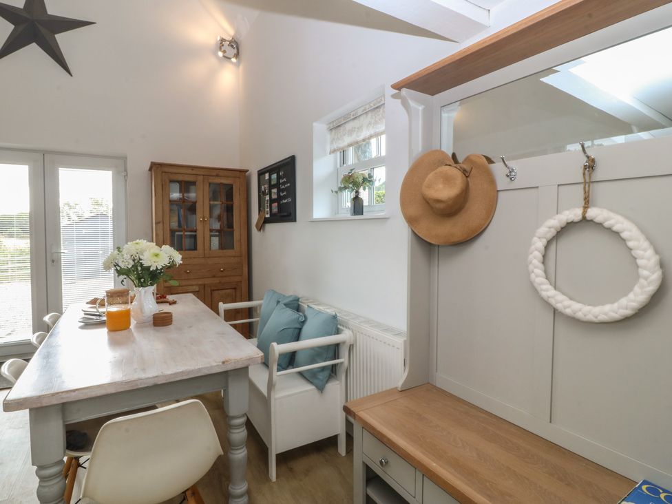 A dining room with a table and chairs at The Byre in Conwy