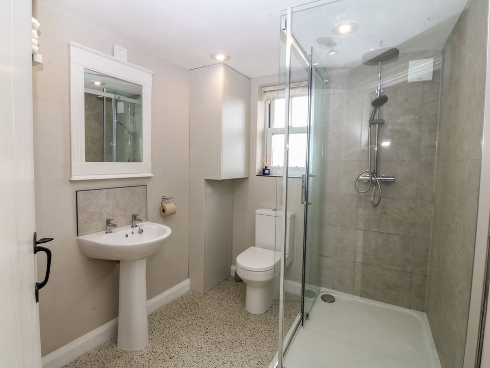A bathroom with a sink, toilet, and shower at The Byre in Conwy