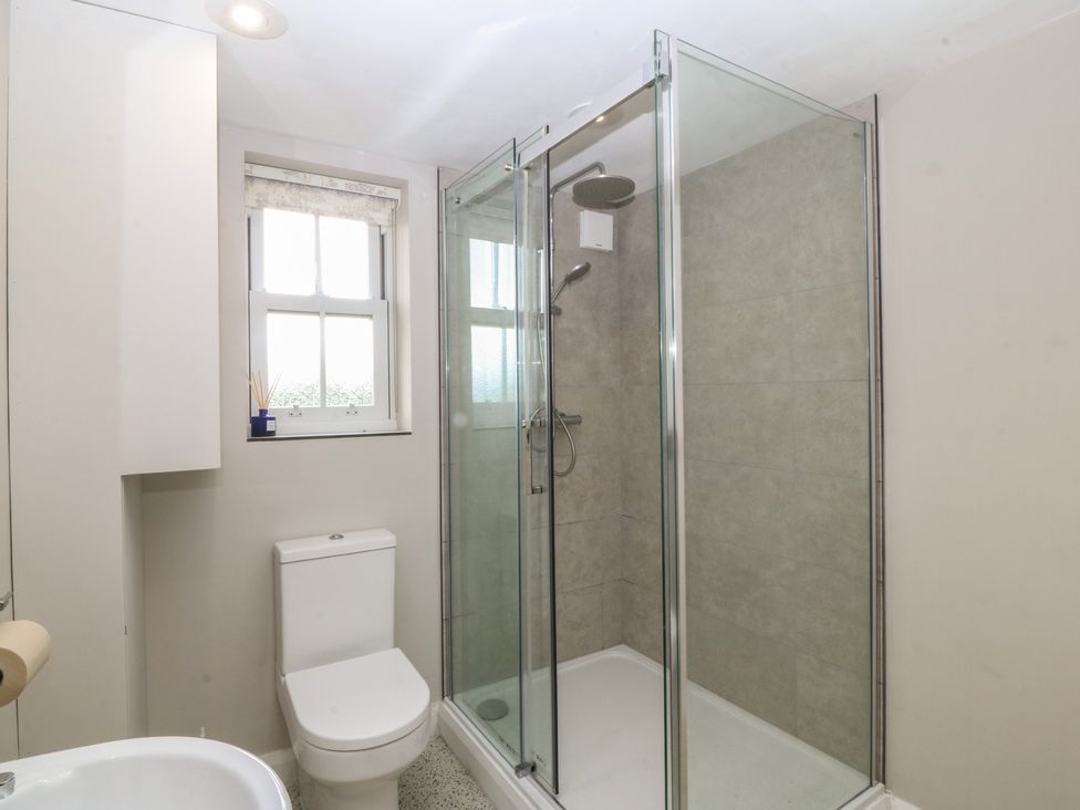 A bathroom with a shower, toilet, and sink at The Byre in Conwy