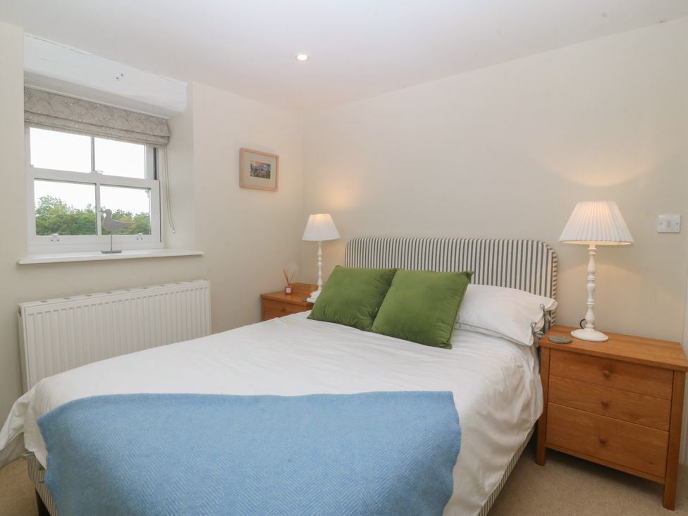 A bedroom with a double bed and lamps at The Byre in Conwy