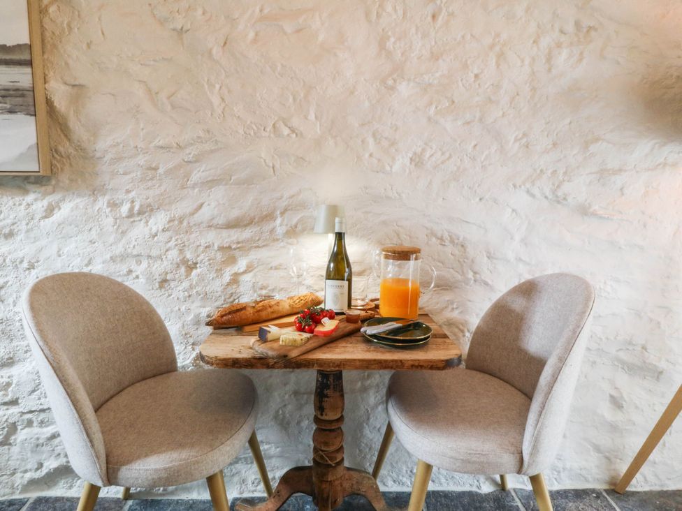 A small dining area with a wooden table and chairs at Little Oak near Tal-Y-Bont