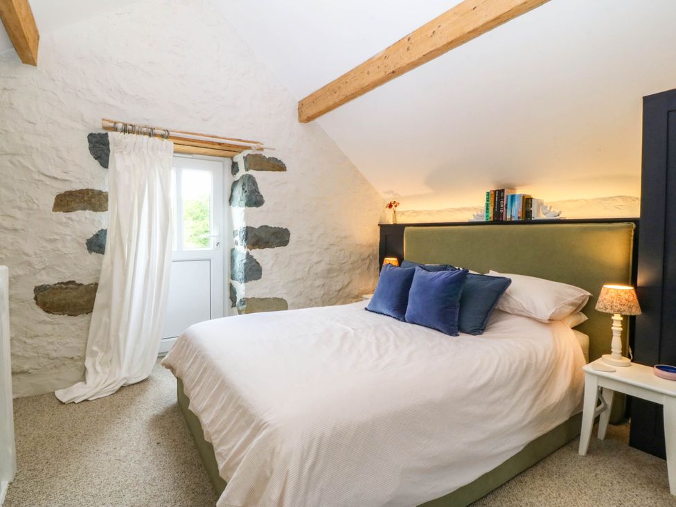 A bedroom with a bed and bedside table at Little Oak near Tal-Y-Bont