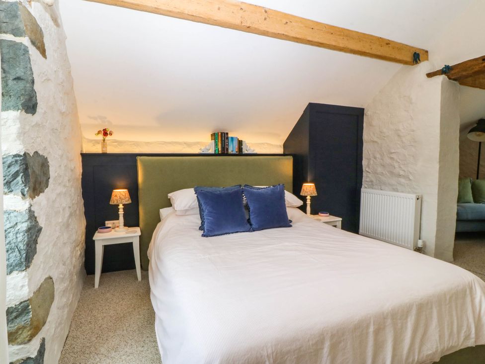A bedroom with a bed and nightstands at Little Oak near Tal-Y-Bont