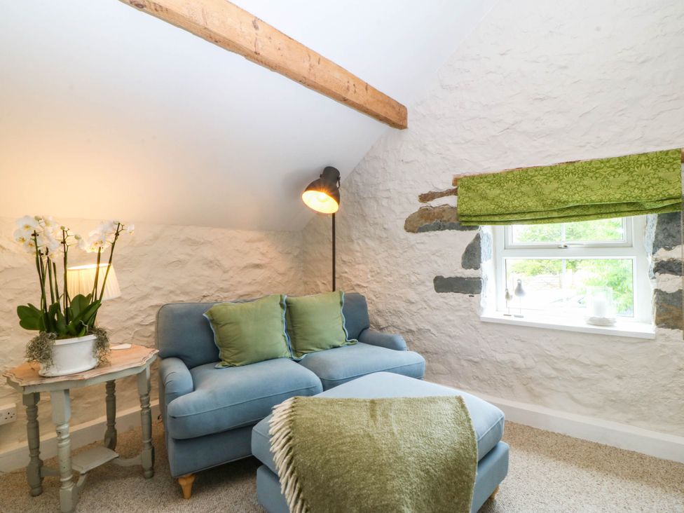 A snug with a sofa and a plant at Little Oak near Tal-Y-Bont