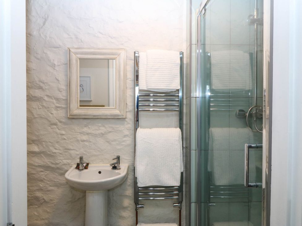 A bathroom with a sink, mirror, towel rack and shower at Little Oak near Tal-Y-Bont