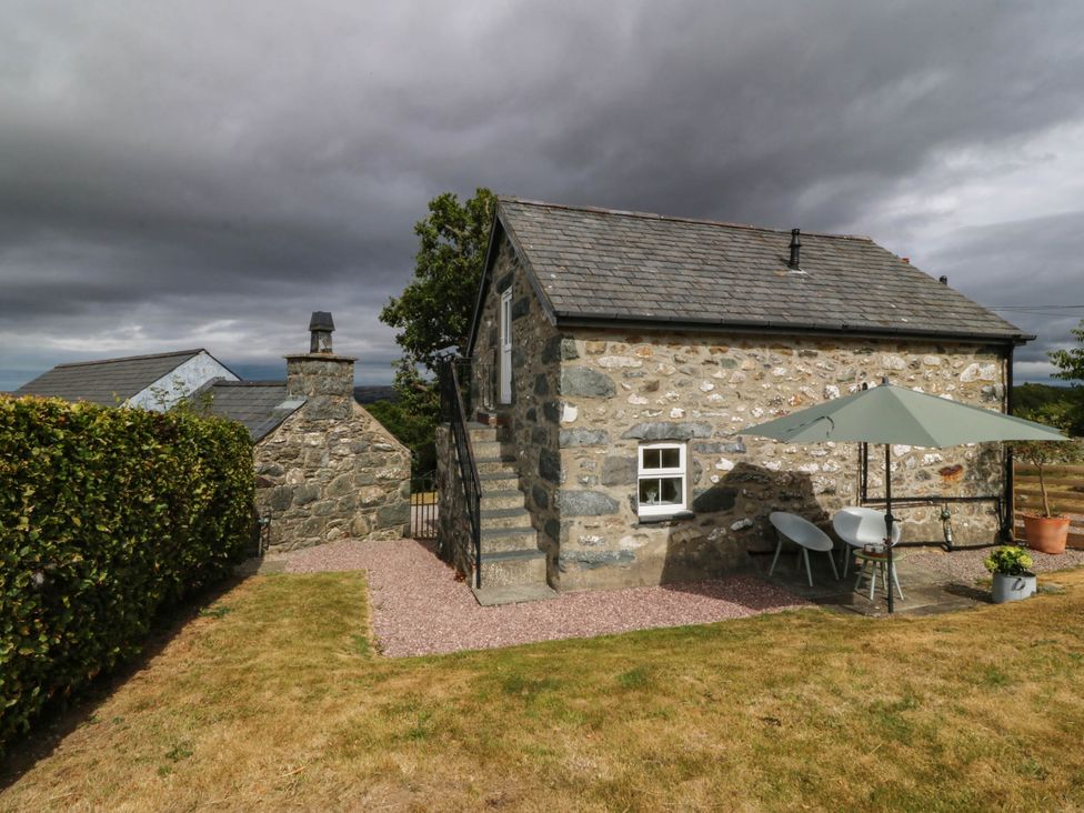 A stone building with stairs and patio furniture at Little Oak near Tal-Y-Bont