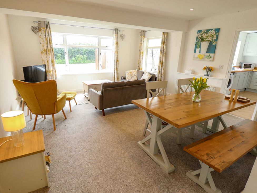 A living room with a sofa and dining area at Field View in North Walsham