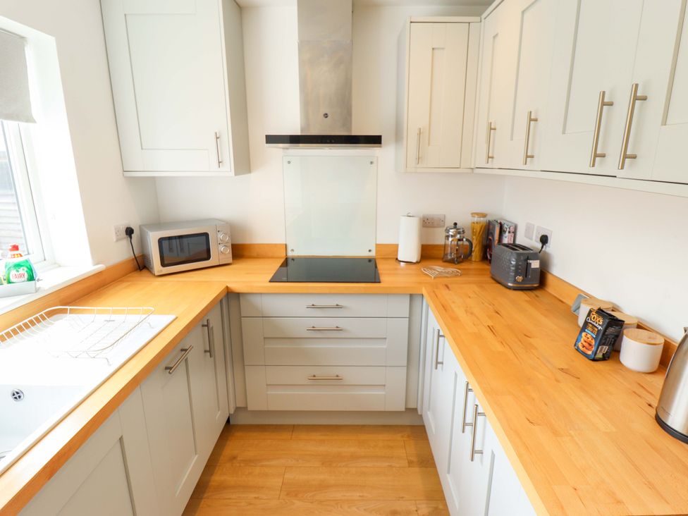 A kitchen with cabinets and appliances at Field View in North Walsham