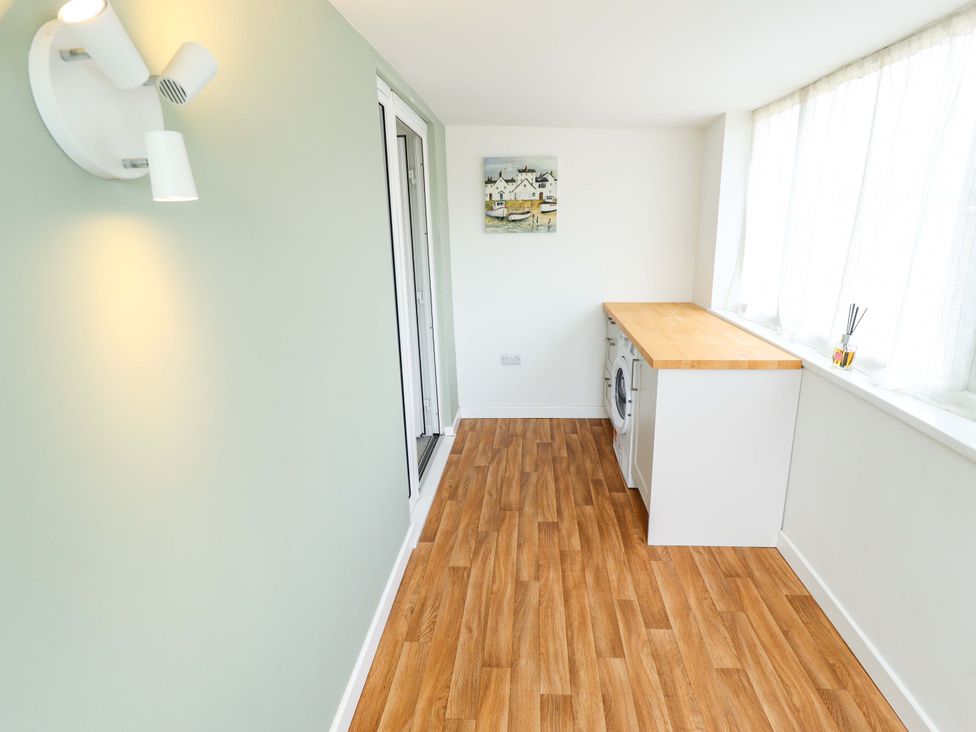 A laundry room with a washing machine and countertop at Field View in North Walsham