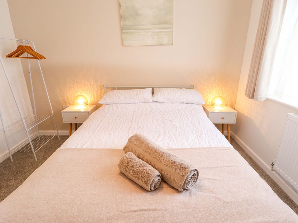 A bedroom featuring a bed with towels on it at Field View, North Walsham