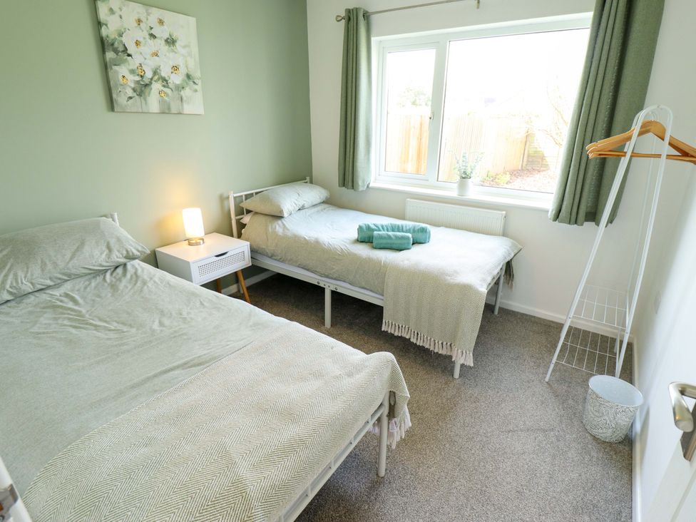 A bedroom with two beds and a window at Field View in North Walsham
