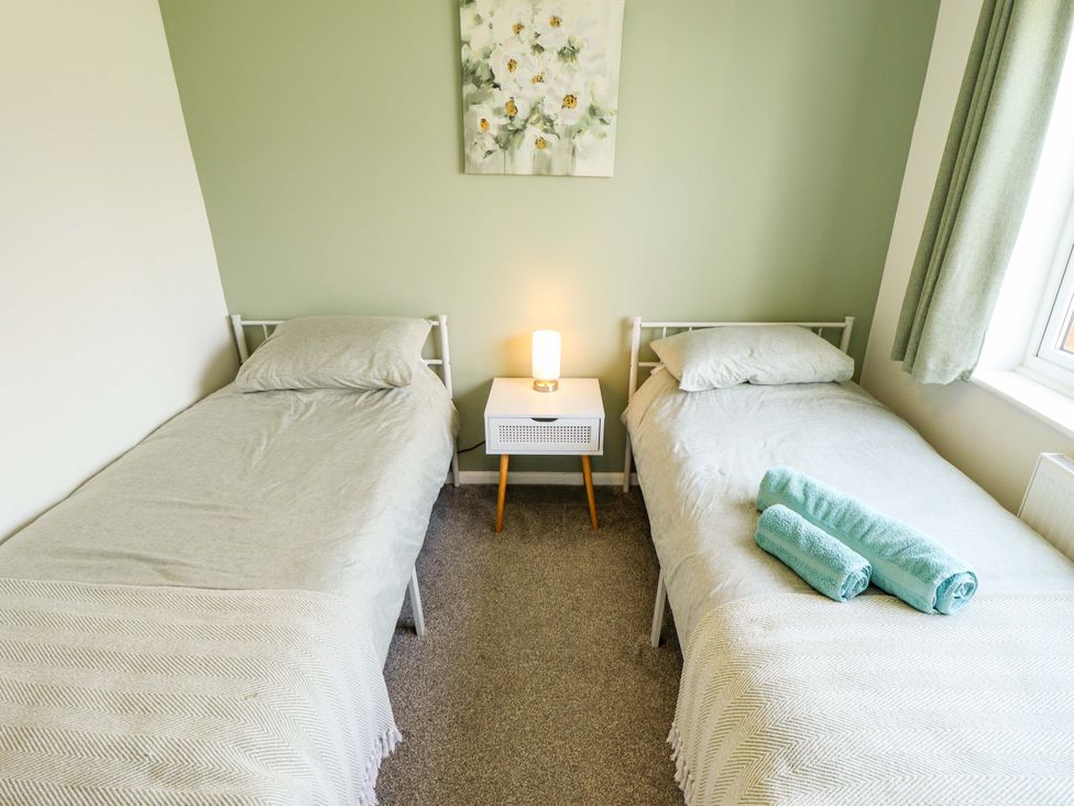 A bedroom with twin beds and a nightstand at Field View in North Walsham