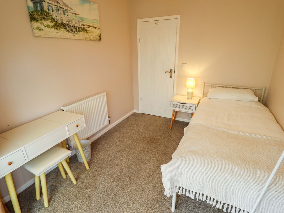 A bedroom with a bed, desk, and lamp at Field View in North Walsham