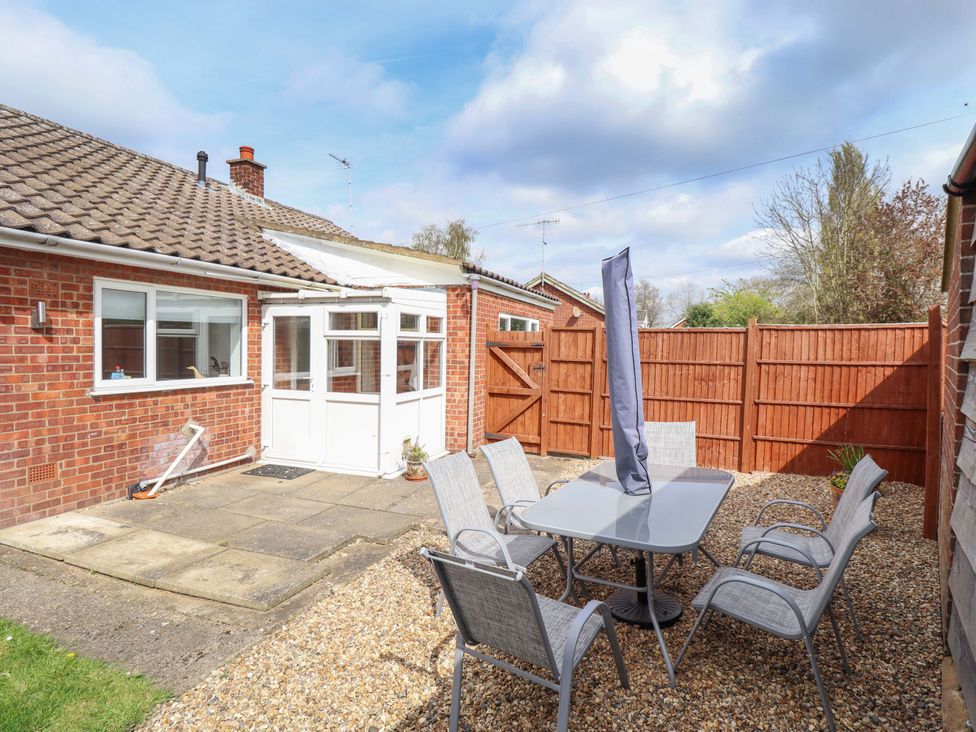 A garden with a table and chairs at Field View in North Walsham