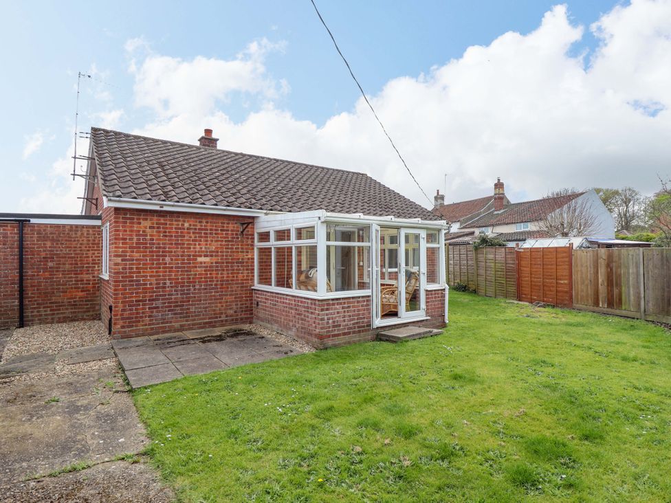 A garden with a conservatory and fence at Field View in North Walsham